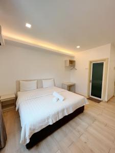 Hutan MelintangVVIP酒店的一间卧室配有一张带白色床单的大床