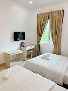 Hutan MelintangVVIP酒店的酒店客房设有两张床和窗户。