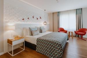 凯麦尔Akra Kemer - Ultra All Inclusive的酒店客房带一张床、一张桌子和椅子