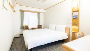 札幌Toyoko Inn Hokkaido Sapporo Susukino Kosaten的酒店客房设有白色的床和窗户。