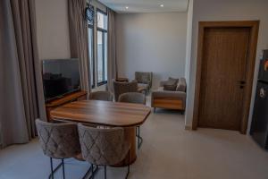 达曼منتجع دلال الفندقي Dalal Hotel Resort的客厅配有桌椅和电视。
