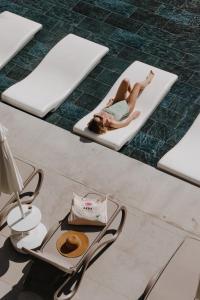 凯麦尔Akra Kemer - Ultra All Inclusive的躺在游泳池的床垫上的女人