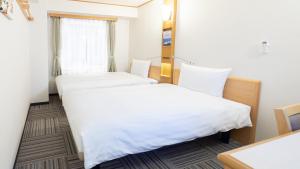 札幌Toyoko Inn Hokkaido Sapporo Susukino Kosaten的配有白色床单的酒店客房内的两张床