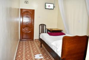 纳库鲁Sundowner Lodge的一间小卧室,配有一张床和一扇木门