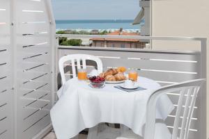 里米尼纳欧迪旅馆的阳台上的一张带一盘食物的白色桌子