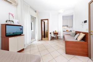里米尼纳欧迪旅馆的客厅配有床和电视。