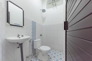 SampitUrbanview Hotel La De Grizz Syariah Sampit by RedDoorz的一间带卫生间、水槽和镜子的浴室