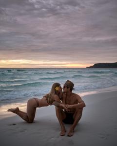 瓜隆岛Sweet Dreams Koh Rong的坐在海滩上的男人和女人