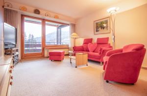 阿罗萨Rehwiesa Studio C24的客厅配有红色椅子和电视