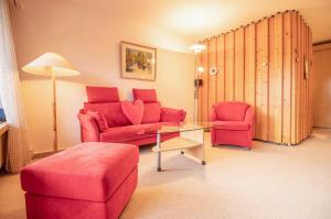 阿罗萨Rehwiesa Studio C24的客厅配有红色的沙发和桌子