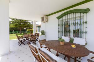 多列毛利诺斯Villa Galemar Pool & Gardens的户外庭院配有木桌和椅子