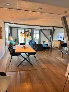 博托比Marielyst, idyllisk feriehus 800m fra torvet的客厅配有木桌和椅子