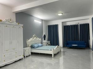 Ấp Long Kiên ITropical Garden的卧室配有白色的床和蓝色的沙发