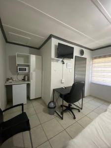 内尔斯普雷特liam travel inn的客房设有带书桌和床的卧室。