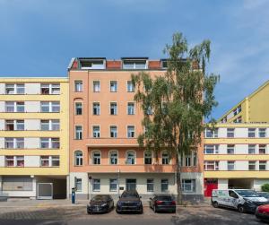 柏林BENSIMON apartments Mitte/Wedding的停车场内有车辆停放的高楼