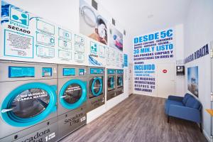 卡斯特利翁-德拉普拉纳RIBALTA SENSACIONES的洗衣房配有4台洗衣机和蓝色沙发
