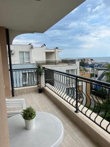 圣弗拉斯Antorini Apartments的阳台配有桌子,享有海景。