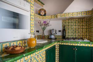 陶尔米纳卡萨安德烈住宿加早餐旅馆的厨房的柜台上铺有黄色和绿色瓷砖