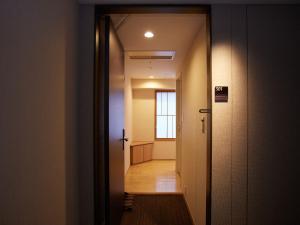 京都京都温泉鸠屋瑞凤阁酒店 的走廊,门通往房间