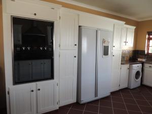科尔切斯特Nukakamma Guest House的厨房配有白色橱柜、洗衣机和烘干机