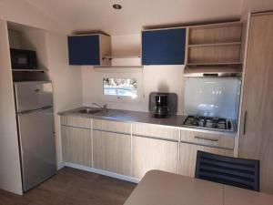 纳博讷普拉日Mobil-home (Clim)- Camping Narbonne-Plage 4* - 011的一间带水槽和冰箱的小厨房