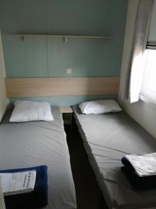 纳博讷普拉日Mobil-home (Clim)- Camping Narbonne-Plage 4* - 011的小型客房配有两张床,