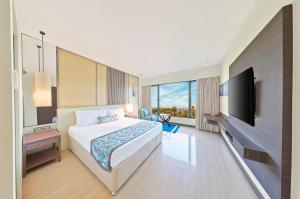 孟买度假酒店的配有一张床和一台平面电视的酒店客房