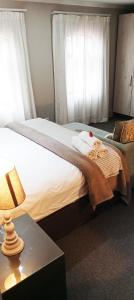 伊丽莎白港Villa Tuscana的一间卧室配有一张床和一张带台灯的桌子