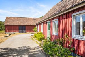 SjöboRaftarp - Country side cottage in the woods的旁边设有车道的红色谷仓
