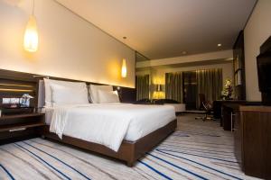 哥印拜陀哥印拜陀艾美度假酒店的酒店客房设有一张大床和一张书桌。