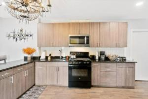 费城Upscale Luxury Suites Minutes From Center City的厨房配有木制橱柜和黑炉灶烤箱。