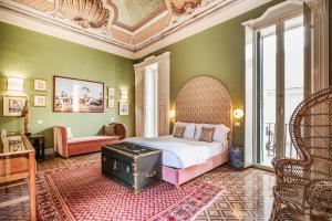 加利波利Palazzo Flora的一间卧室配有一张床、一把椅子和一张桌子