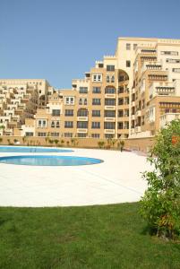 拉斯阿尔卡麦Hala Holiday Homes- Bab Al Bahr Residence, Al Marjan Island的一座大型公寓楼前的空水池
