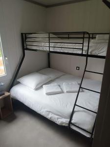 阿斯帕朗Erreka pays basque的一间卧室配有带白色床单和枕头的双层床