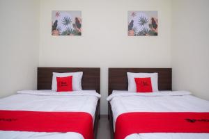 Kalibanteng-kidulRedDoorz near Kawasan Bandara Ahmad Yani Semarang 2的客房内的两张床和红色枕头
