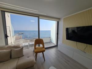 都拉斯Sea view luxury duplex的带沙发和大窗户的客厅