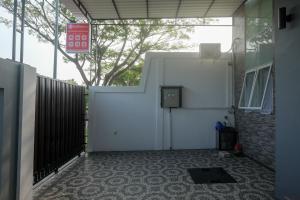 Kalibanteng-kidulRedDoorz near Kawasan Bandara Ahmad Yani Semarang 2的车库设有白色门和围栏
