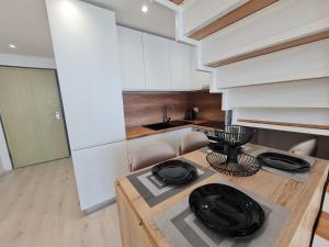 都拉斯Sea view luxury duplex的厨房配有一张带黑色中心台的木桌