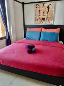考陶Las Tortugas, Cozy condominium on Khao Tao beach, Hua Hin的一张有红色床罩的床,上面有一只动物塞满了