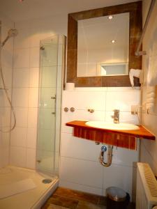 上施陶芬Vital Lodge Allgäu mit Oberstaufen PLUS的浴室配有盥洗盆和带镜子的淋浴