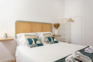里斯本Lisbon Zoo House III的卧室配有白色的床和2个枕头