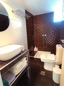 斯基亚索斯镇Inna Suite luxury apartment in the center的一间带水槽、浴缸和卫生间的浴室