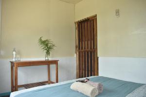 鲁滕Mama's Homestay Ruteng的一间卧室配有一张床和一张植物桌子