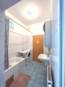 维也纳7brunnen Hostel & Guest House的带浴缸、水槽和洗衣机的浴室