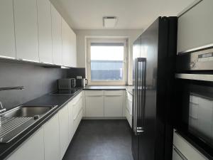 汉堡"Live Good, Work Good" - Stadion Apartment by GG Rental Hamburg的厨房配有白色橱柜、水槽和窗户。