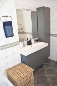圣克鲁斯-德特内里费Beachfront Apartment - Tacoronte的浴室设有水槽、镜子和柳条凳