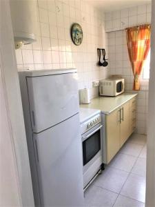 贝纳尔马德纳Acuario shared flat piso compartido est partagé الشقة مشتركة的厨房配有白色冰箱和微波炉