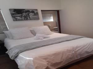 帕尔帕达布特自助式小屋酒店的卧室配有一张带白色床单和枕头的大床。