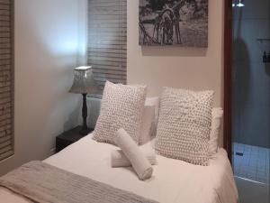 帕尔帕达布特自助式小屋酒店的一间卧室配有带白色枕头和灯的床