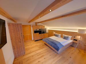 上施陶芬Haus Denneberg的一间卧室设有一张大床,铺有木地板。